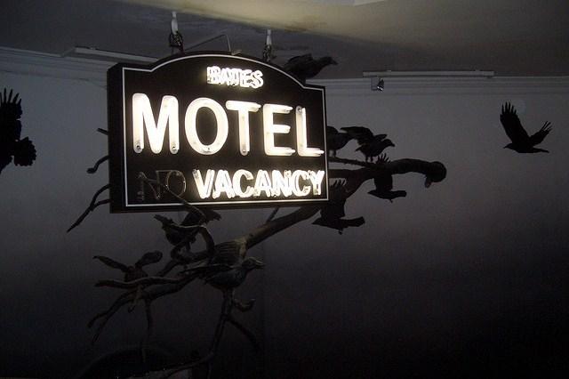 A model of the "Bates Motel, No Vacancy" sign from Psycho. it's surrounded by taxidermy birds.