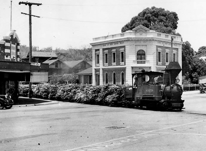 File:'Moreton' locomotive hauls a sugarcane tram across Currie Street, Nambour (cropped).png