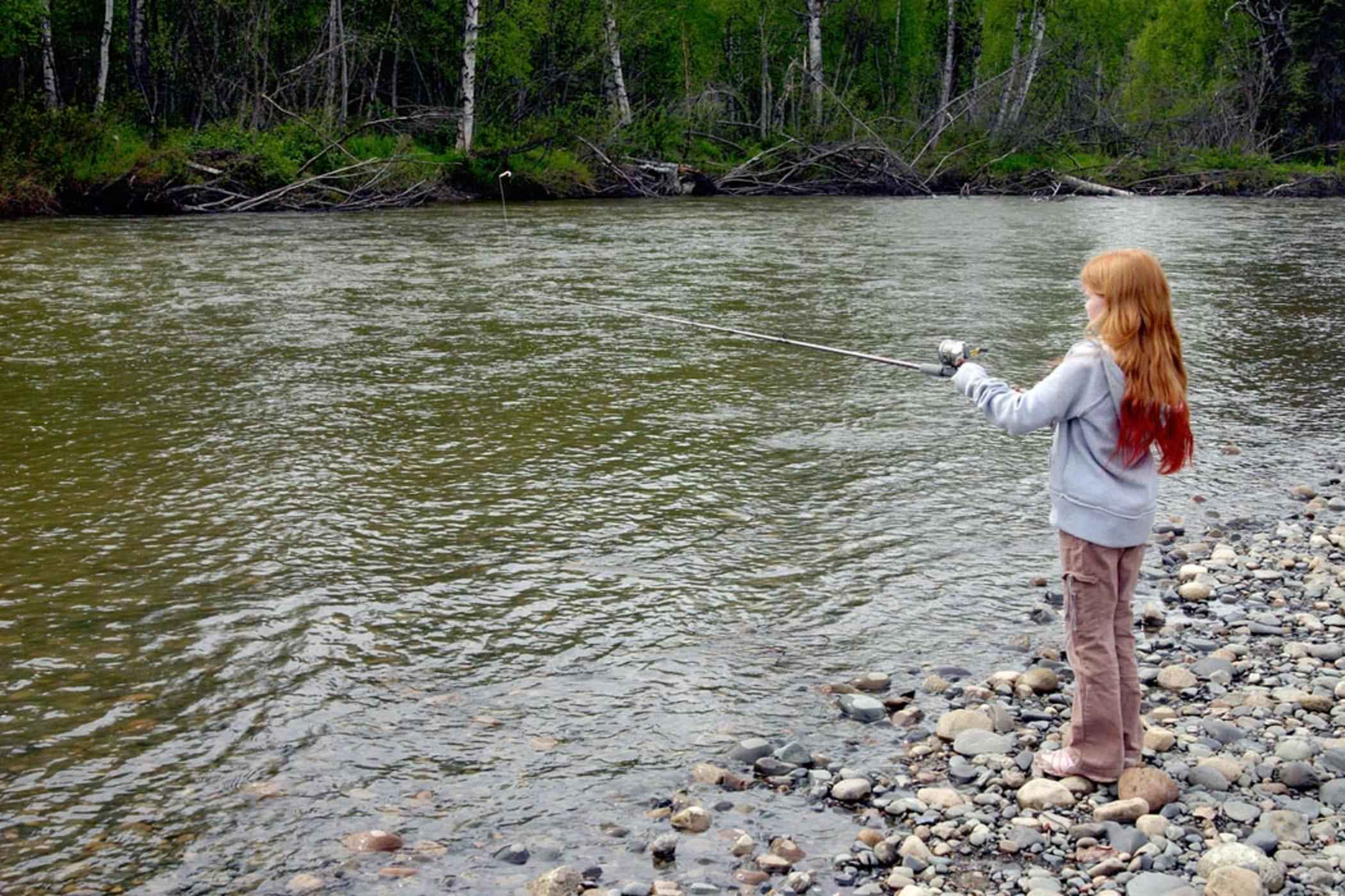 File:Girl stands on shore and fishes with her fishing rod.jpg - Wikimedia Commons