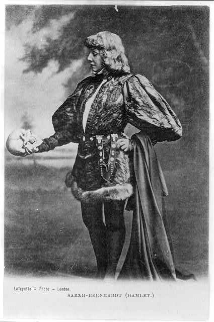 Print shows Sarah Bernhardt as Hamlet, full-length portrait, standing, facing left, holding and looking at skull.
