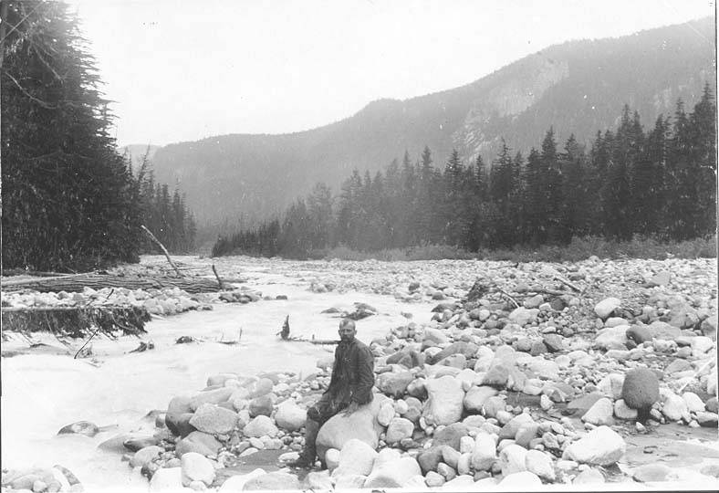File:Man sitting on boulder next to the Nisqually River near Longmire Springs, ca 1895 (SARVANT 2).jpeg