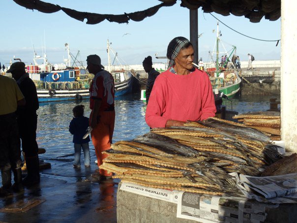 File:Woman smoking a cigarette behind a fish stall in South Africa.jpg