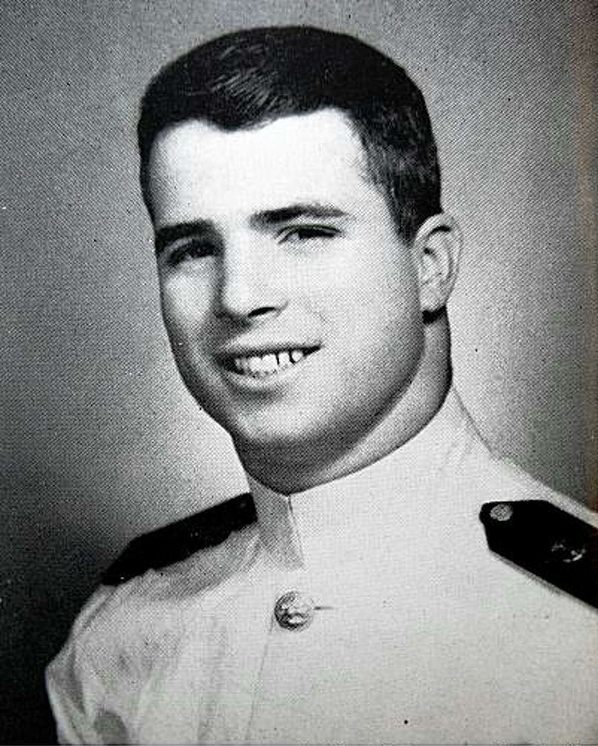 Oficjalny portret młodego, ciemnowłosego mężczyzny w białym mundurze marynarki wojennej