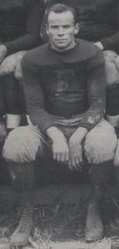 Posed Foto von Wray sitzend und in einer Fußballuniform mit einem 