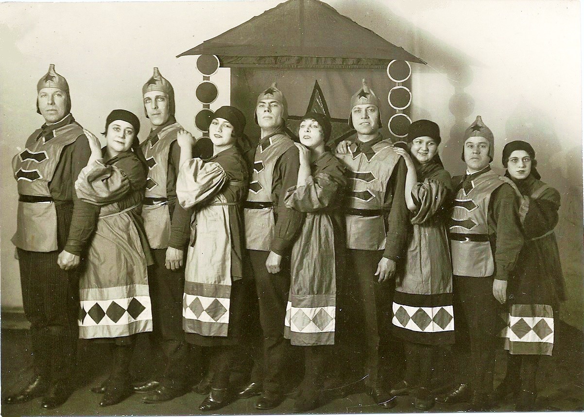 Black and white photograph of a Blue Blouse troupe circa 1928, 5 women and 5 men, all in medieval looking tunics, lined up from left to right, man, women, man women etc.