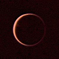 An image of Titan's nightside taken by Voyager 2 on August 25, 1981 as it departed the Saturnian system. The hazy atmosphere of Titan scatters sunlight from its dayside around the entire moon, causing Titan to light up like a ring.