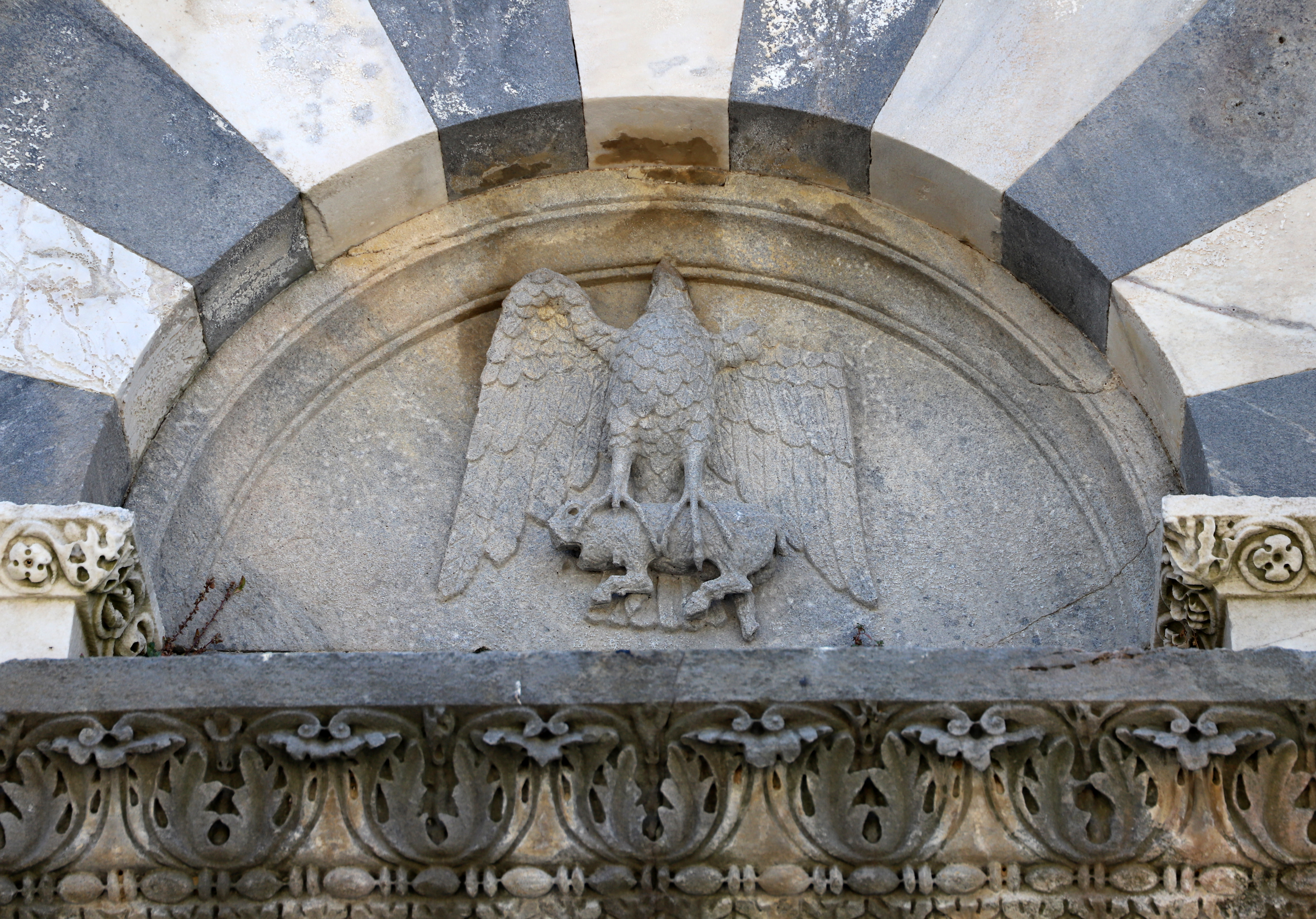 Pieve di San Giovannii, portale laterale (particolare, un aquila che ghermisce un quadrupede)