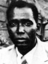 Fotografia ravvicinata di un uomo africano, a capo scoperto, con una giacca leggera e una cravatta.