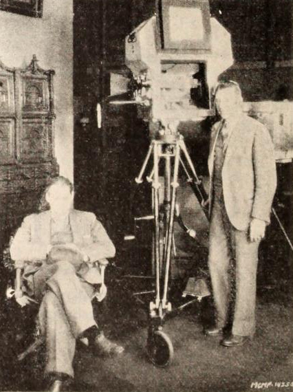John Anderson (standing) with Lionel Barrymore on the set of the 1929 film, The Unholy Night, the housing around the camera is Arnold's invention, the "bungalow"