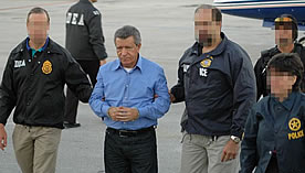 DEA agents escort Colombian drug lord Miguel Rodríguez Orejuela after his extradition to the United States in 2005.