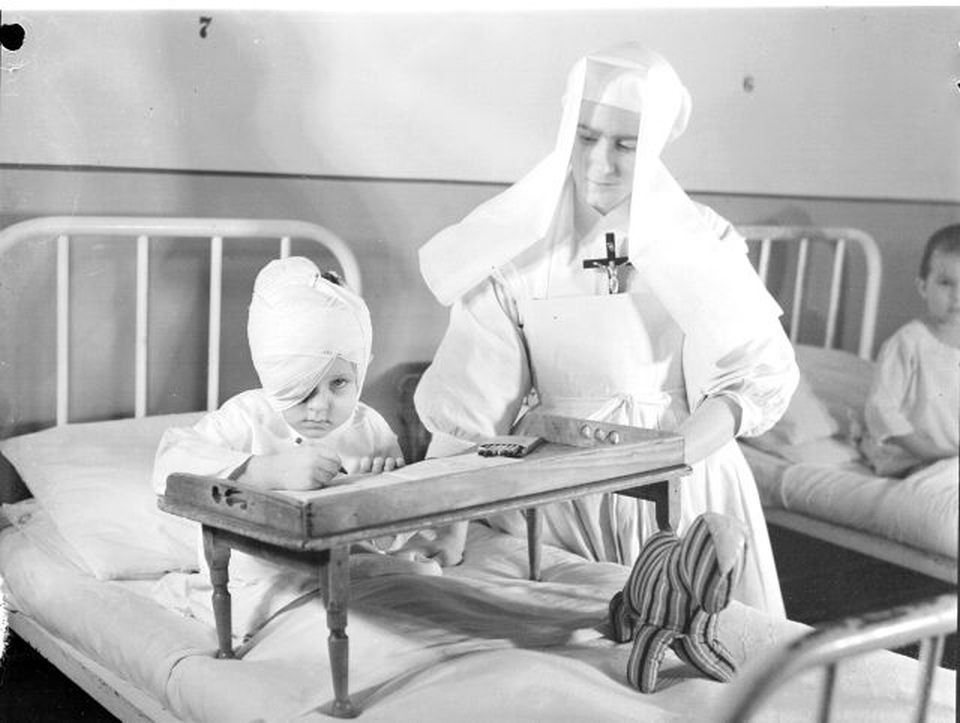 A member of the Daughters of Wisdom caring for an injured child in the [[Centre hospitalier universitaire Sainte-Justine|Hospital Sainte-Justine]] of [[Montreal]] in 1945