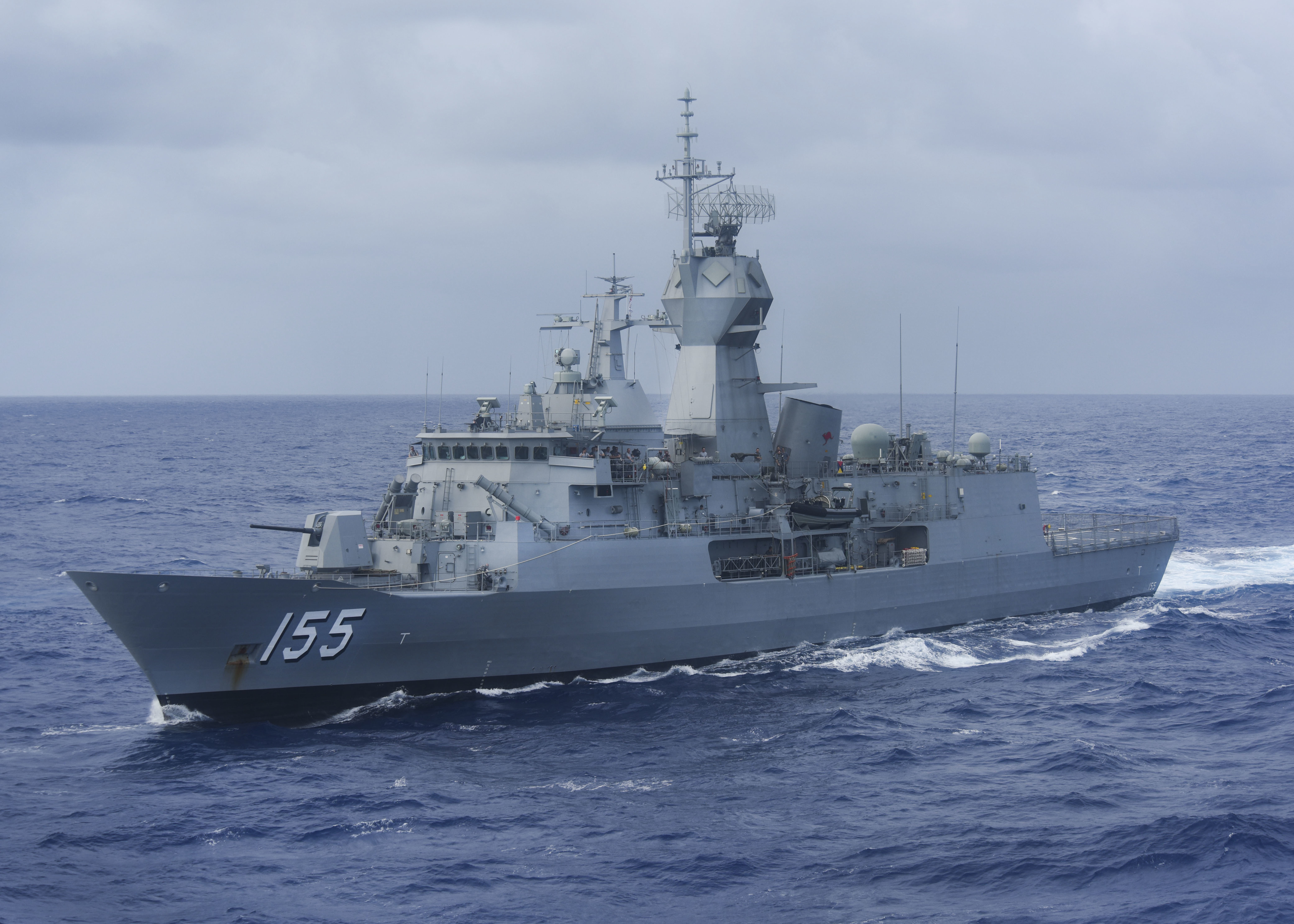 The Anzac class (also identified as the ANZAC class and the MEKO 200 ANZ type) is a ship class of ten frigates; eight operated by the Royal Australian Navy (RAN) and two operated by the Royal New Zealand Navy (RNZN). During the 1980s, the RAN began plans to replace the River-class destroyer escorts (based on the British Leander class frigate) with a mid-capability patrol frigate and settled on the idea of modifying a proven German design for Australian conditions. Around the same time, the RNZN was seeking to replace their Leander-class frigates while maintaining blue-water capabilities. A souring of relations between New Zealand and the United States of America in relation to New Zealand's nuclear-free zone and the ANZUS security treaty prompted New Zealand to seek improved ties with other nations, particularly Australia. As both nations were seeking warships of similar capabilities, the decision was made in 1987 to collaborate on their acquisition. The project name (and later, the class name) is taken from the Australian and New Zealand Army Corps of the First World War.
Twelve ship designs were tendered in 1986. By 1989, the project had selected a proposal by Germany's Blohm + Voss, based on their MEKO 200 design, to be built in Australia by AMECON at Williamstown, Victoria. The modular design of the frigates allowed sections to be constructed at Whangārei, New Zealand and Newcastle, New South Wales in addition to Williamstown. The RAN ordered eight ships, while the RNZN ordered two and had the option to add two more. The frigate acquisition was controversial and widely opposed in New Zealand, and as a result, the additional ships were not ordered.
In 1992, work started on the frigates; 3,600-tonne (3,500-long-ton) ships capable of a 27-knot (50 km/h; 31 mph) top speed, and a range of 6,000 nautical miles (11,000 km; 6,900 mi) at 18 knots (33 km/h; 21 mph). The armament initially consisted of a single 5-inch gun and a point-defence missile system, supported by a missile-armed helicopter. In addition, the ships were fitted for but not with a torpedo system, anti-ship missiles, and a close-in weapons system. The last ship of the class entered service in 2006; by this point, the RAN and RNZN had embarked on separate projects to improve the frigates' capabilities by fitting the additional weapons, along with updates to other systems and equipment.
Since entering service, Anzac-class frigates have made multiple deployments outside local waters, including involvement in the INTERFET multi-national deployment to East Timor, and multiple operational periods in the Persian Gulf. As of 2014, all ten ships are in service. The RAN intends to start replacing theirs in 2027 when their first Hunter-class frigate is commissioned, while the RNZN ships will remain active until the mid-2030s.