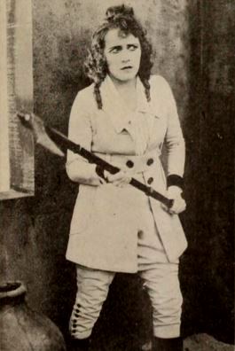 Movie still of Ruth Roland holding an axe