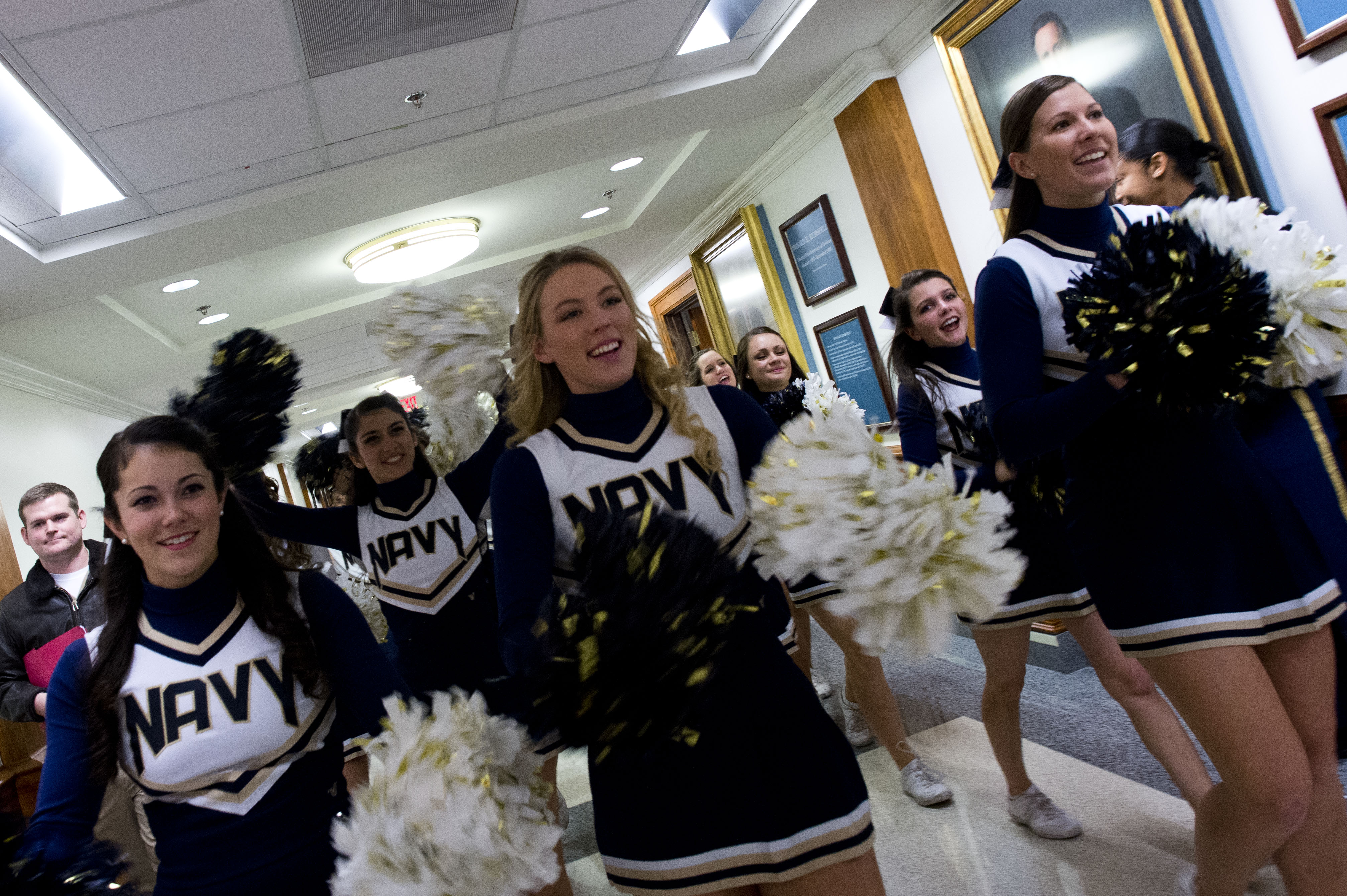 U.S. Naval Academy cheerleaders conduct a pep rally outside Secretary of De...