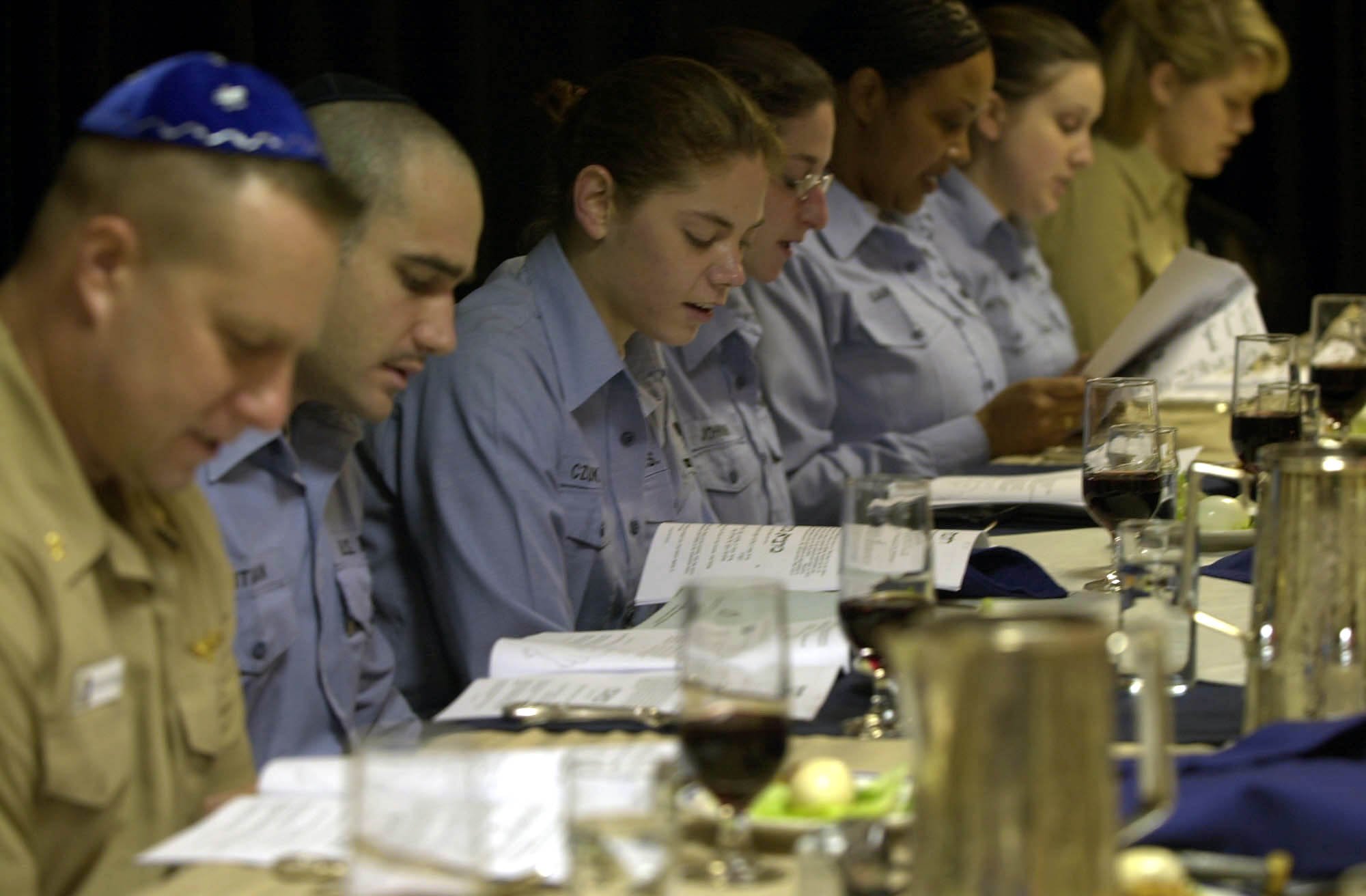 US Navy 030417-N-8273J-010 Crewmembers read from the Passover Hagaddah (prayer book) during the Passover Seder dinner in the wardroom aboard USS Nimitz (CVN 68).jpg