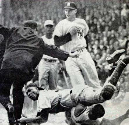 Howard during a collision at home plate, 1961 World Series. The umpire is Jocko Conlan.