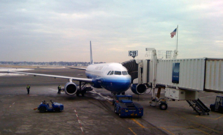 File:Boston Logan Gate C19 with Flag and Jet.jpg