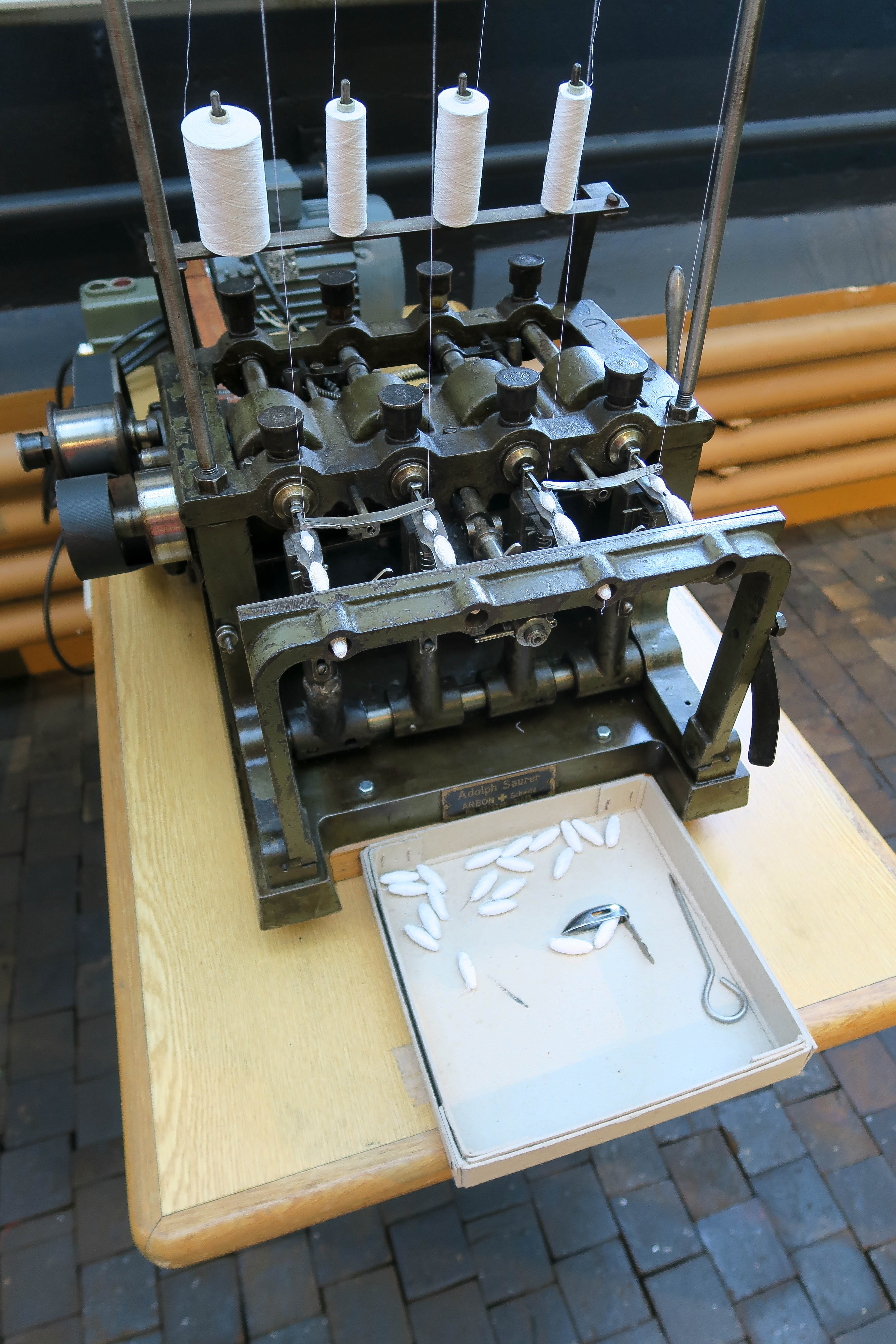 https://upload.wikimedia.org/wikipedia/commons/a/a6/Schiffli_embroidery_bobbin_thread_winding_machine.jpg