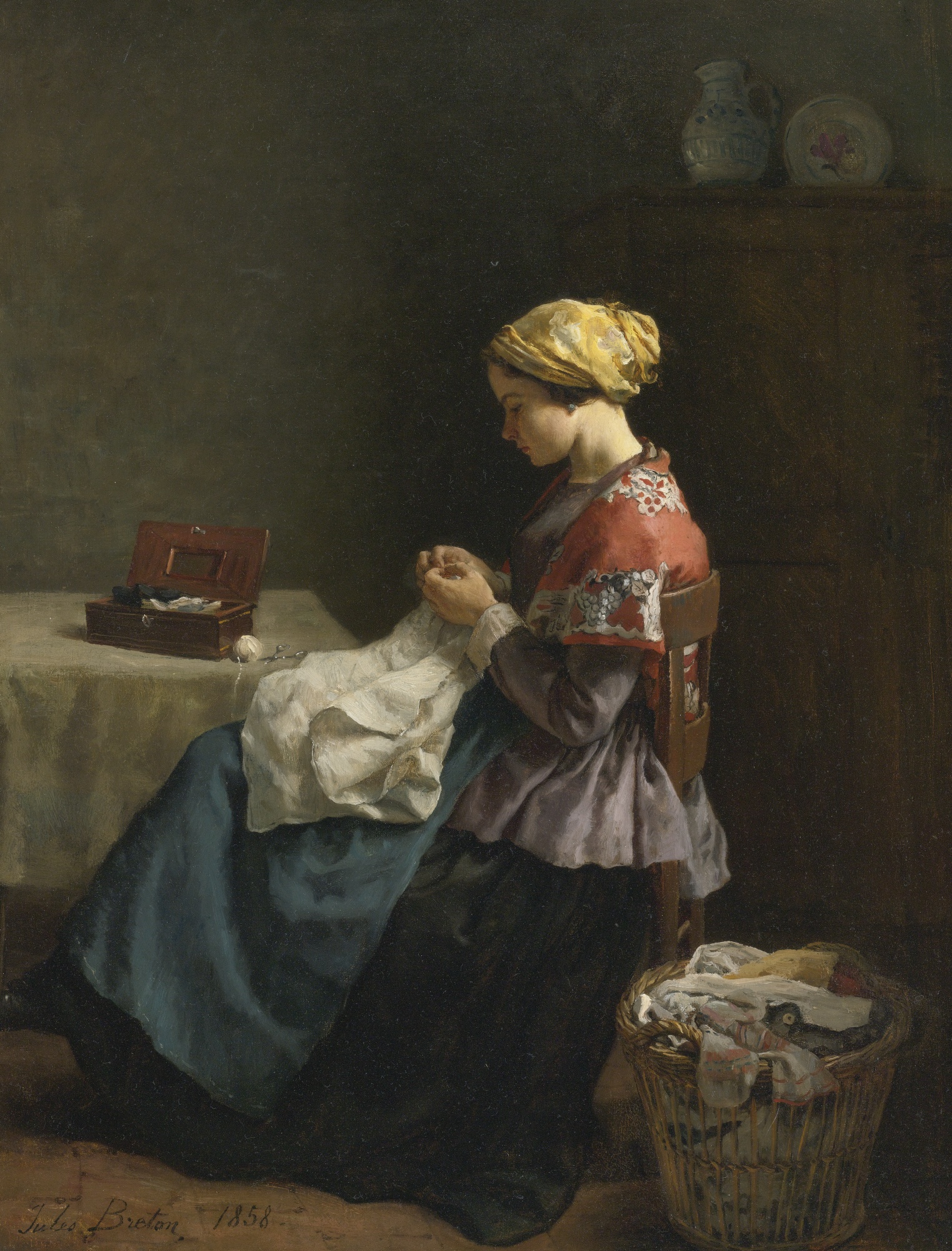 Painting: a woman sits by a table sewing. On the table is an open sewing box. On the floor beside her is a basket of sewing, possibly mending.