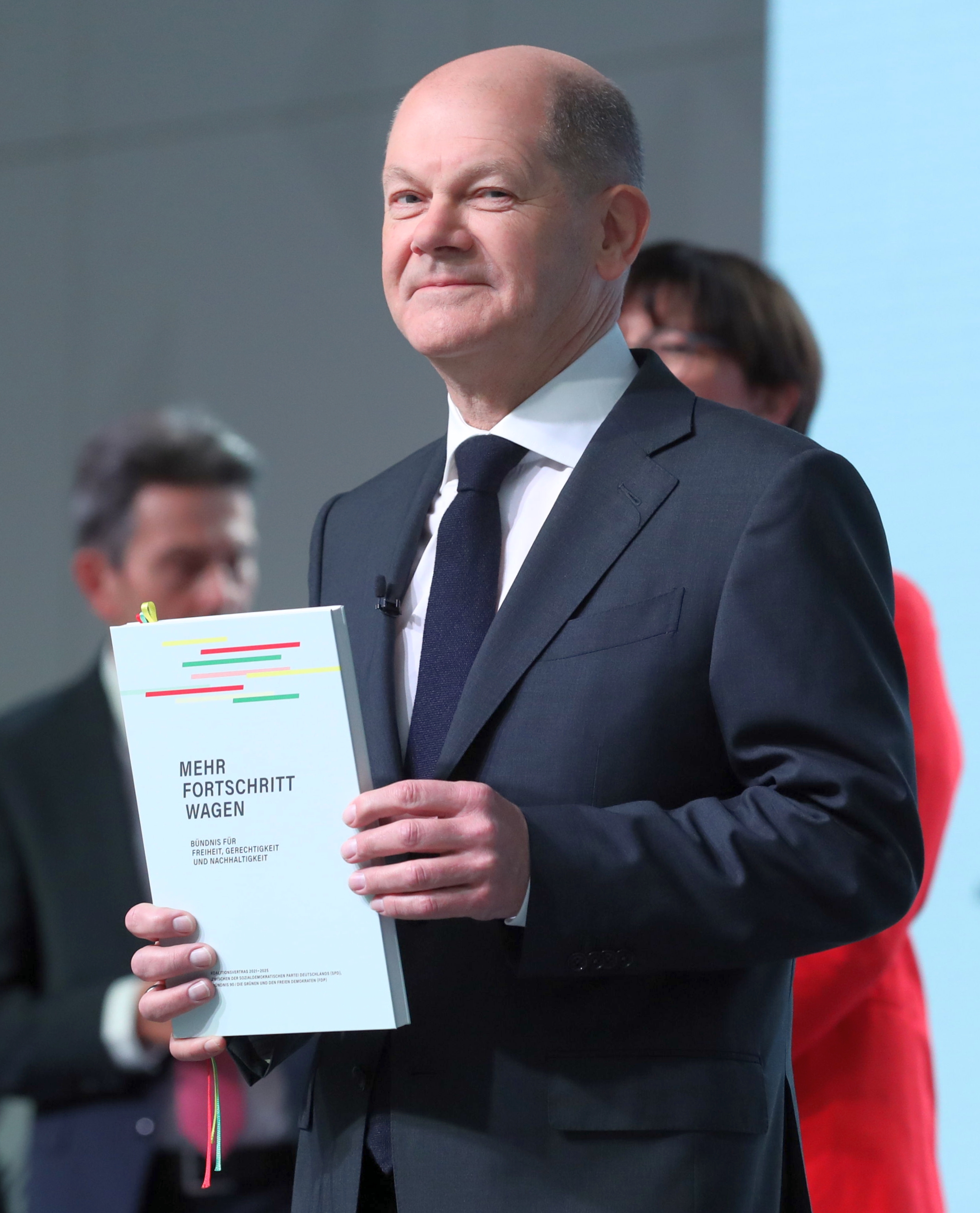Olaf Scholz hält ein Exemplar des Koalitionsvertrags in der Hand