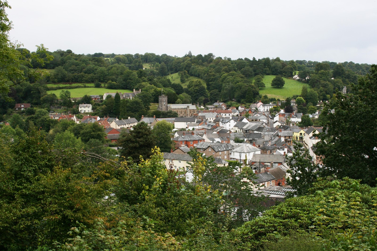 View through trees to historical small town with a church.