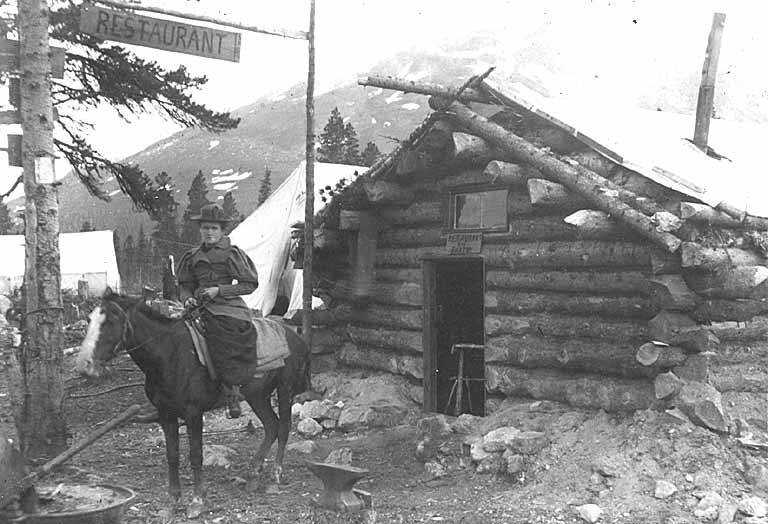 File:Florence Hartshorn on horseback in front of log restaurant, Log Cabin, White Pass Trail, British Columbia, 1898 (AL+CA 529).jpg