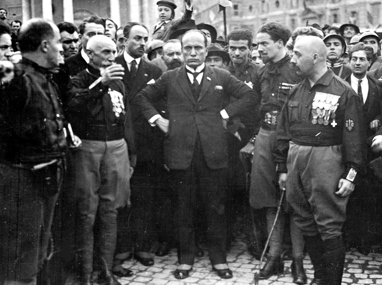 Benito Mussolini at the fascist congress in Naples, held as a "general test" for the march on Rome implemented a few days later; with him some of the quadrumvirs: from left Emilio De Bono, Italo Balbo and Cesare Maria De Vecchi.