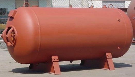 A welded steel pressure vessel constructed as a horizontal cylinder with domed ends. An access cover can be seen at one end, and a drain valve at the bottom centre.