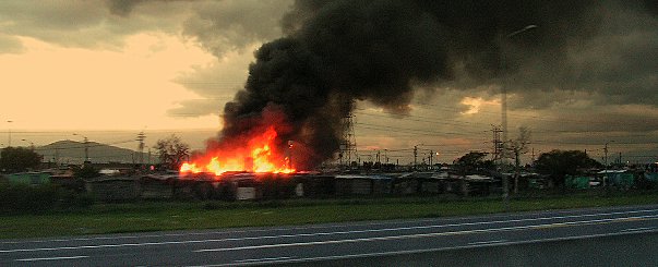 File:Shacks on fire.jpg