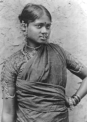 A photograph of a nautch girl posed against a wall