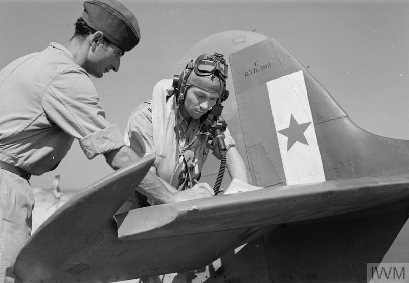 File:Watched by his rigger (left), a pilot of No. 352 Squadron, the first operational Yugoslav unit in the RAF, signs the aircraft serviceability form for his Supermarine Spitfire Mark VC on the tailplane of the aircraft,.jpg