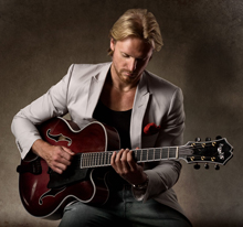 Pozowane zdjęcie Öberga patrzącego na swoją gitarę
