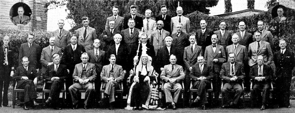 Формальная фотография около 30 политиков, стоящих и сидящих в четырех рядах.