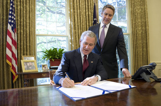 With Sen. Bill Frist (R-TN) looking on, President George W. Bush signs into law Pub.L. 109–353 (text) (PDF), the North Korea Nonproliferation Act of 2006, on October 13, 2006.