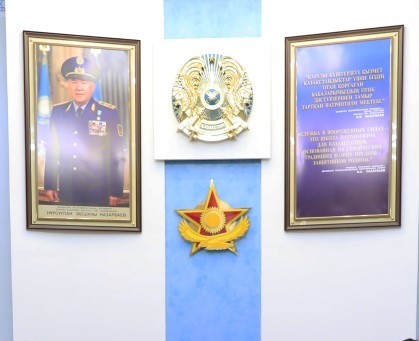 A hall in the National Defense University featuring national symbols as well as a photo of its patron, Nursultan Nazarbayev, in full dress uniform.