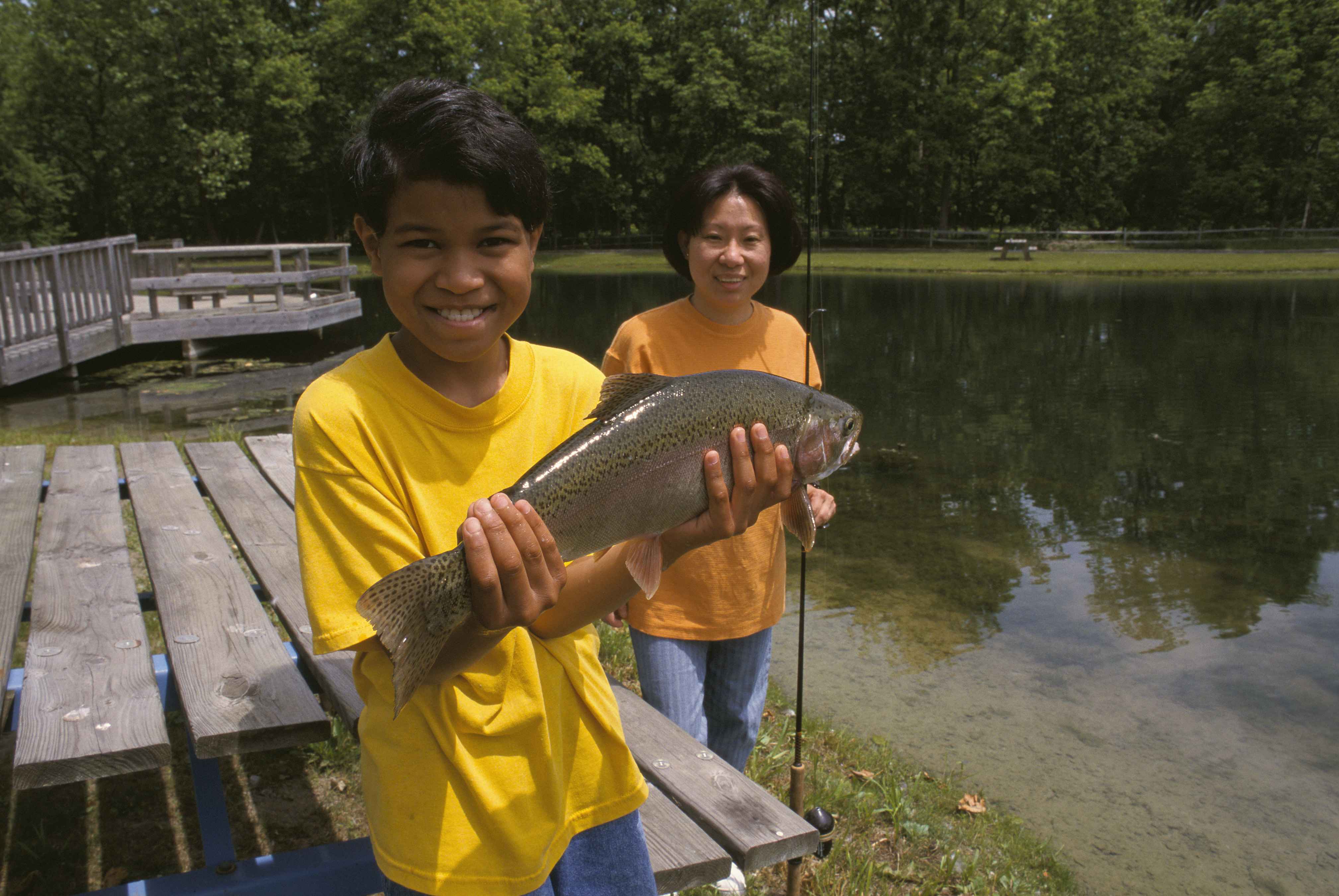 File:Son showing trout fish he caught mother stads proudly behind at  lake.jpg - Wikimedia Commons