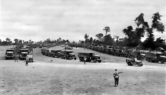Trucks of the Red Ball Express, organized to supply Allied forces in France after break-out from the D-Day beaches, moving through a regulating point, 1944