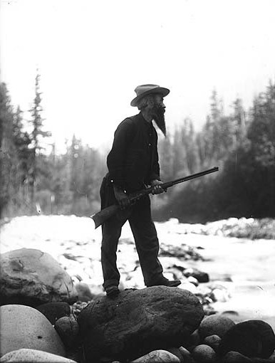 File:Elcaine Longmire with rifle standing on large boulder in riverbed, Mount Rainier National Park, Washington, ca 1907 (BAR 30).jpeg