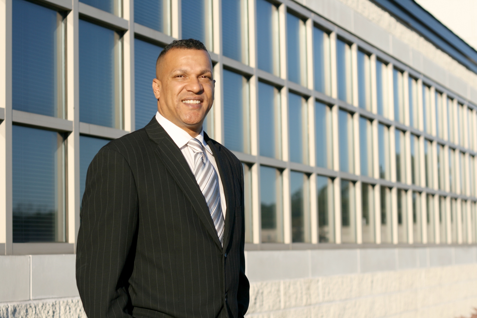 [Image: Man_in_biz_suit_in_front_of_office_windows.jpg]