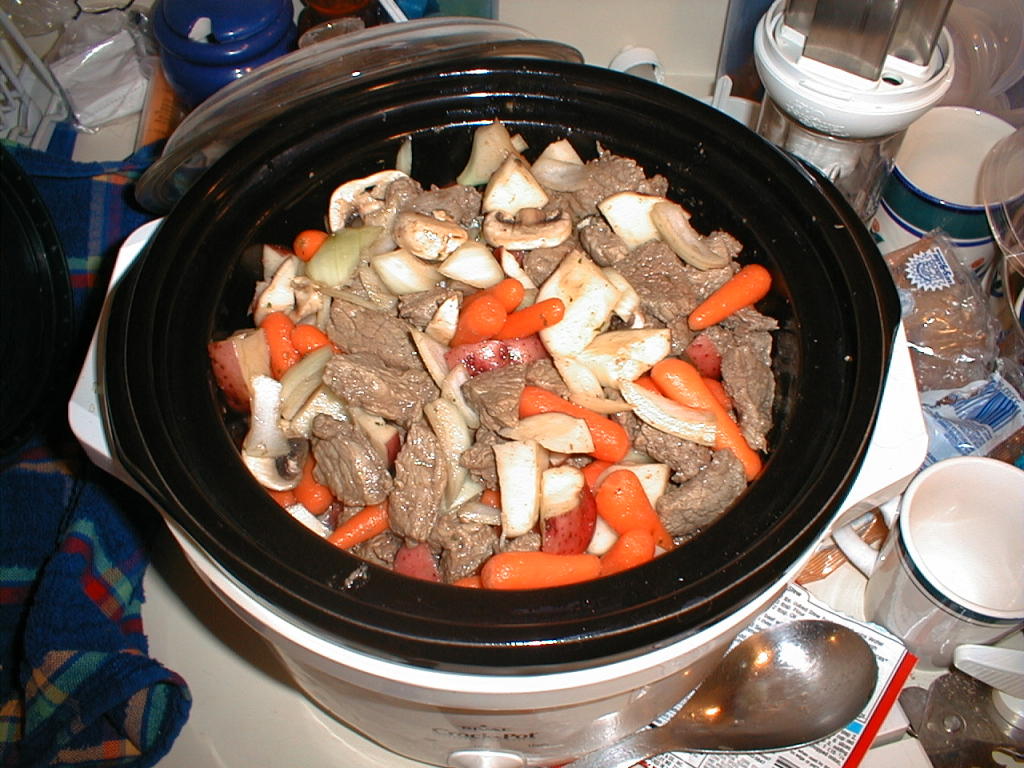 Slow cooker with meat and vegetables in it