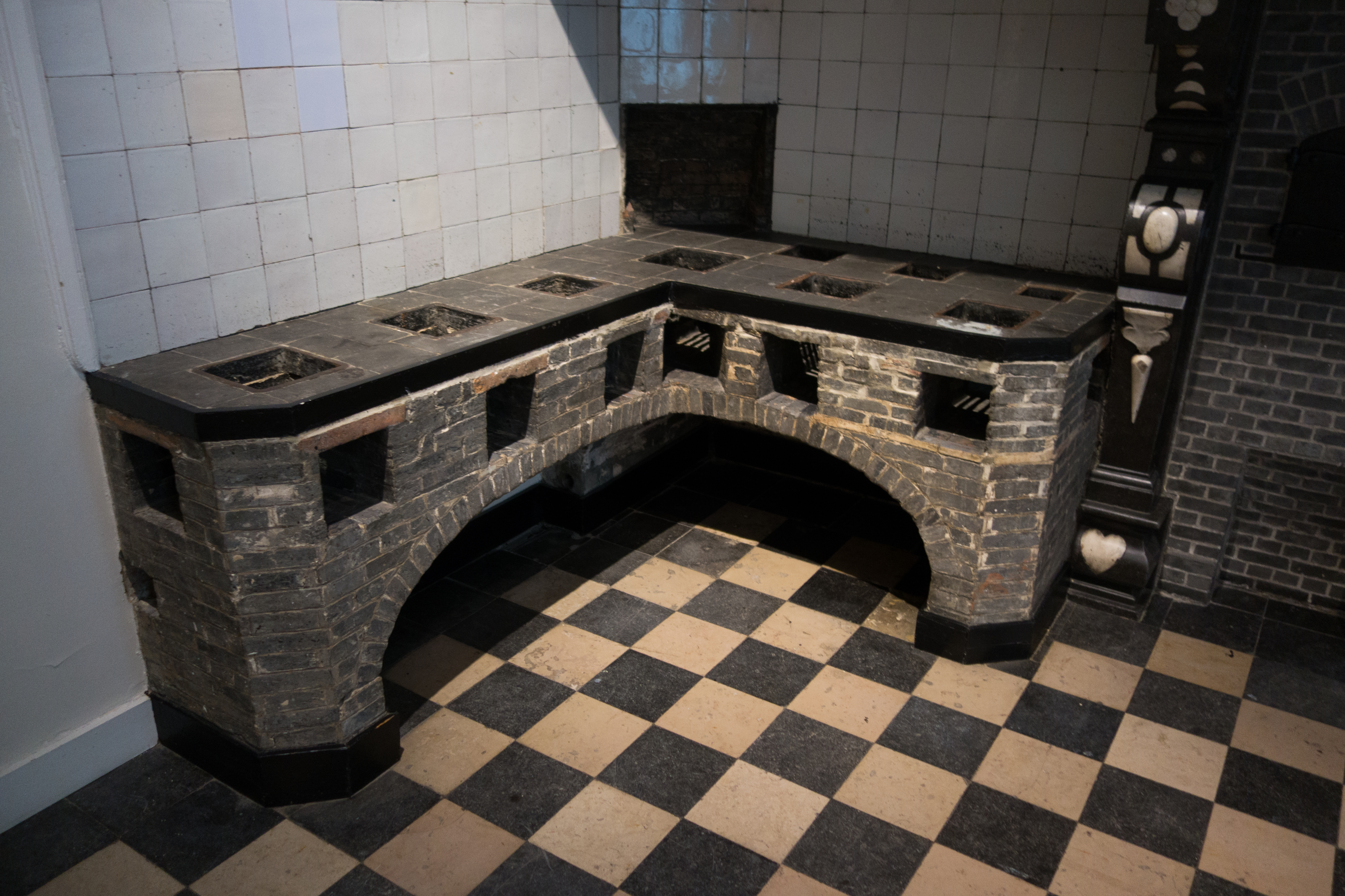 Seven holes are visible in the stone tile top of this brick-based stove.