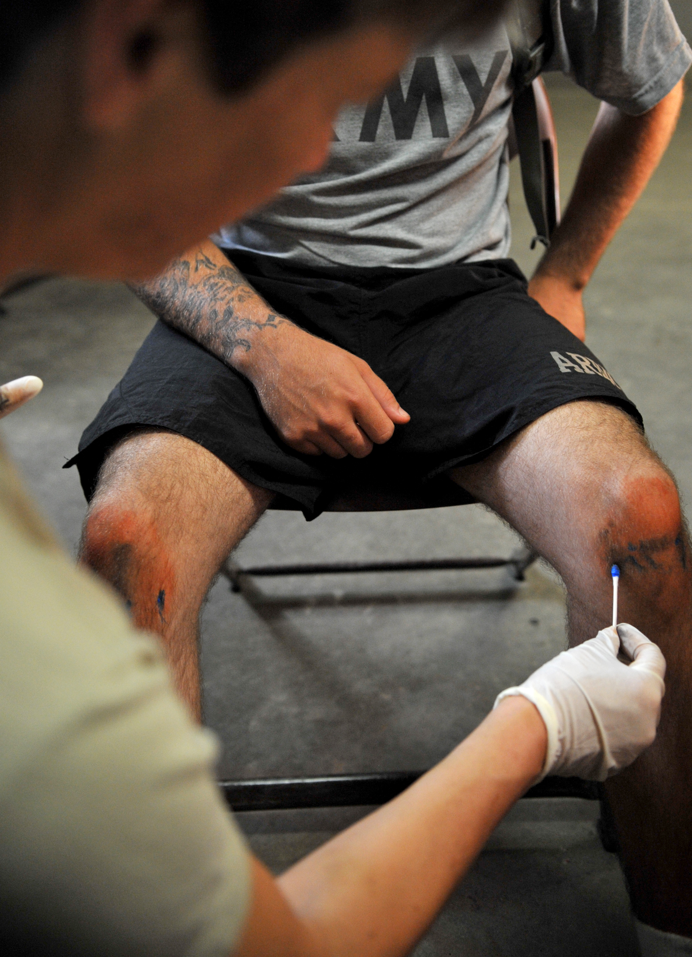 professional nurse from the 161st Multi-functional Medical Battalion, applies moulage makeup for a simulated injury, during an exercise involving a boy scout