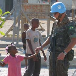 Een Braziliaanse MINUSTAH-blauwhelm en een Haïtiaans meisje.