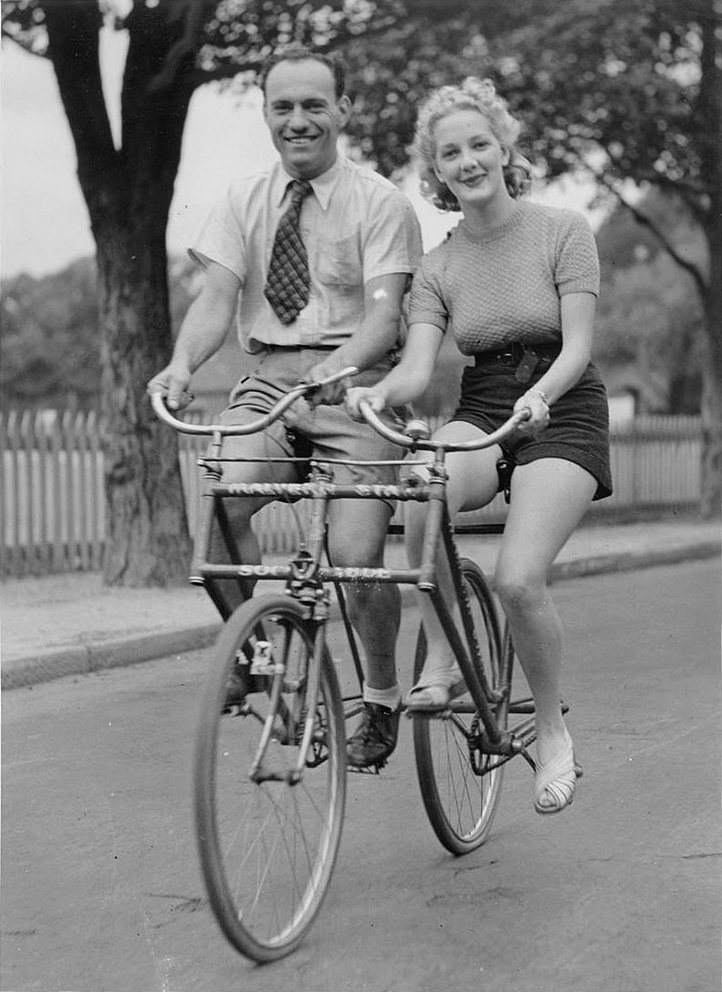Man_and_woman_on_a_Malvern_Star_abreast_tandem_bicycle%2C_c._1930s%2C_by_Sam_Hood.jpg