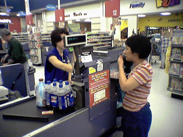 A cashier and a customer interact at a cash register