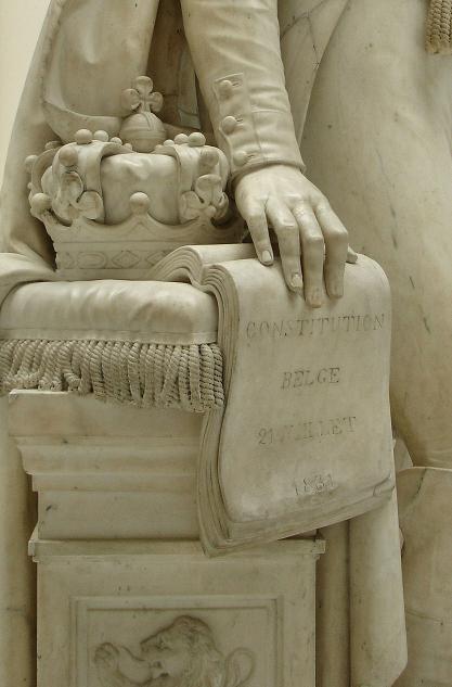 The heraldic Belgian crown, symbolically resting on the constitution in a statue of Leopold I.