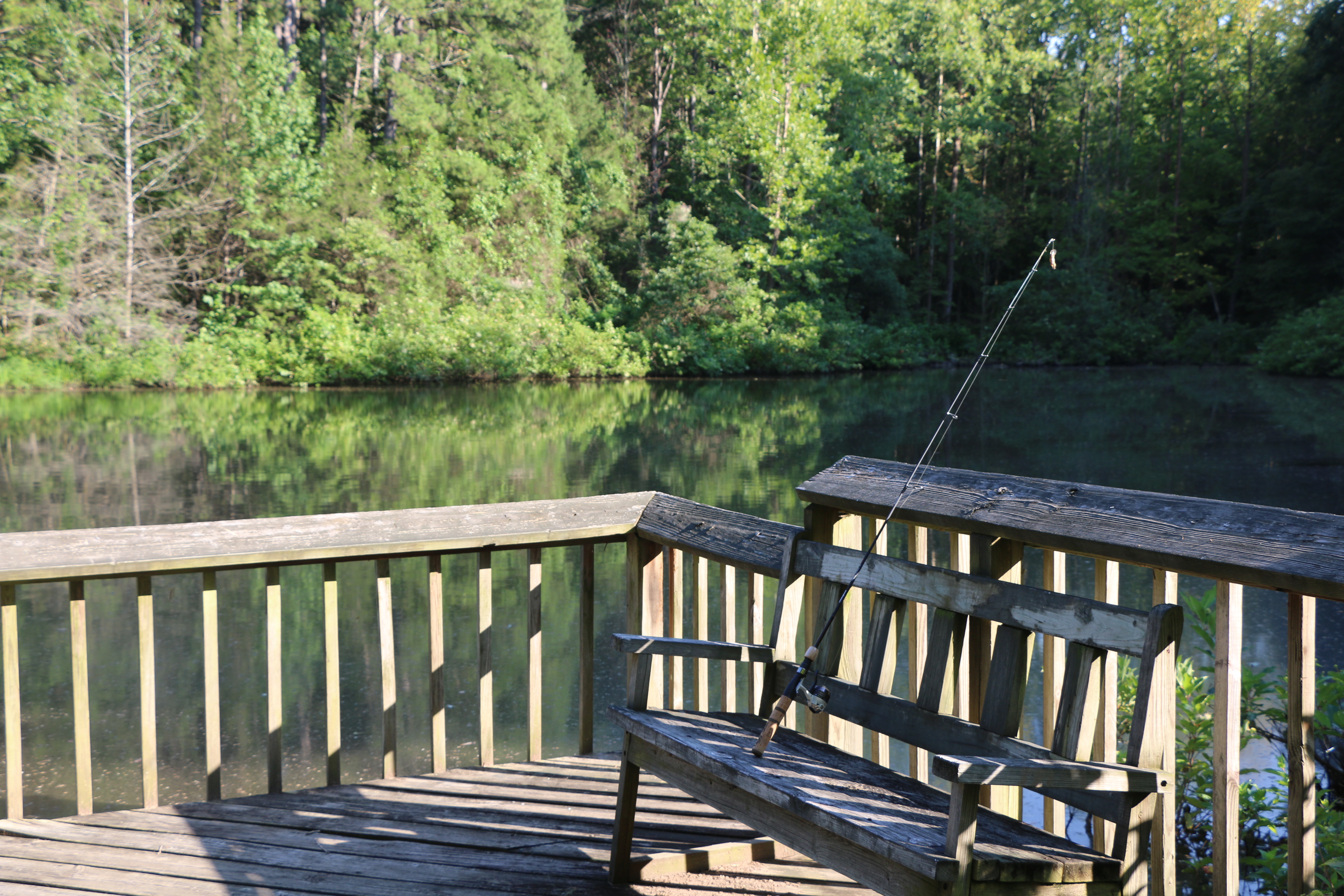 File:A fishing pole leans against the railing of a fishing dock on