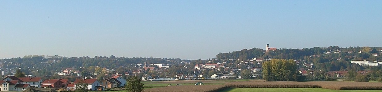 Panoramaaufnahme von Pfarrkirchen. In der Mitte ist die Pfarrkirche erkennbar, rechts der Gartlberg mit der zweitürmigen Wallfahrtskirche