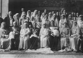 Los Reyes Alfonso XIII y Victoria Eugenia con un grupo de familiares y cargos palatinos en la boda de la Infanta Isabel Alfonsa de Borbón. Las señoras visten uniforme de Dama de la Reina.