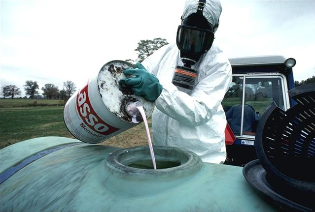 A USDA employee pouring hazardous chemicals into a storage container.^[[Image](https://commons.wikimedia.org/wiki/File:Hazardous-pesticide.jpg) by [USDA](https://www.usda.gov/) is in the public domain]